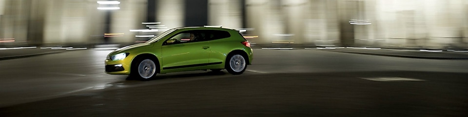 Зелений автомобіль швидко їде вночі